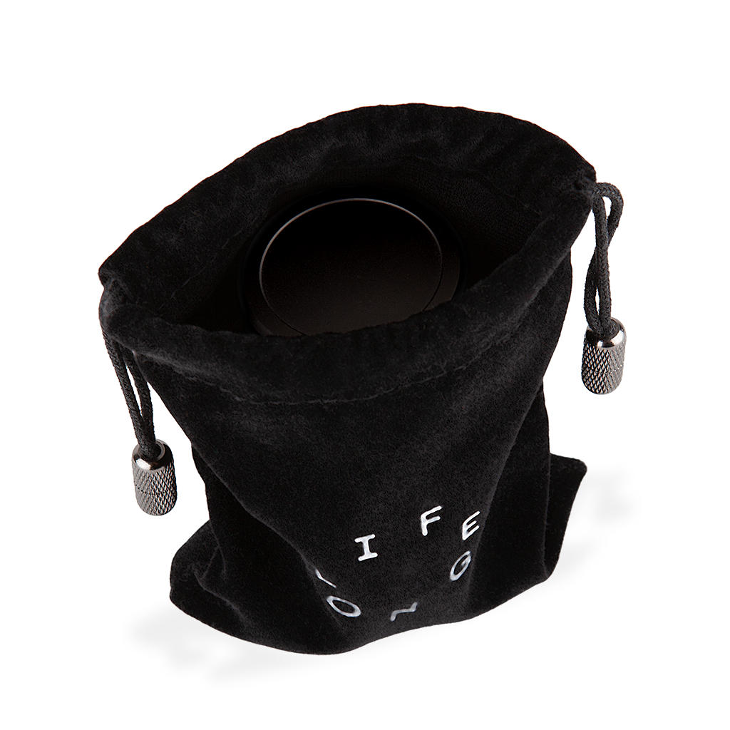 Black travel bag for refillable deodorant  from the brand Lifelongdeo. Bag is velvet with a circle white logo saying Lifelong. The straps has knurled metal details in the ends. You can see the deodorant in the bag.