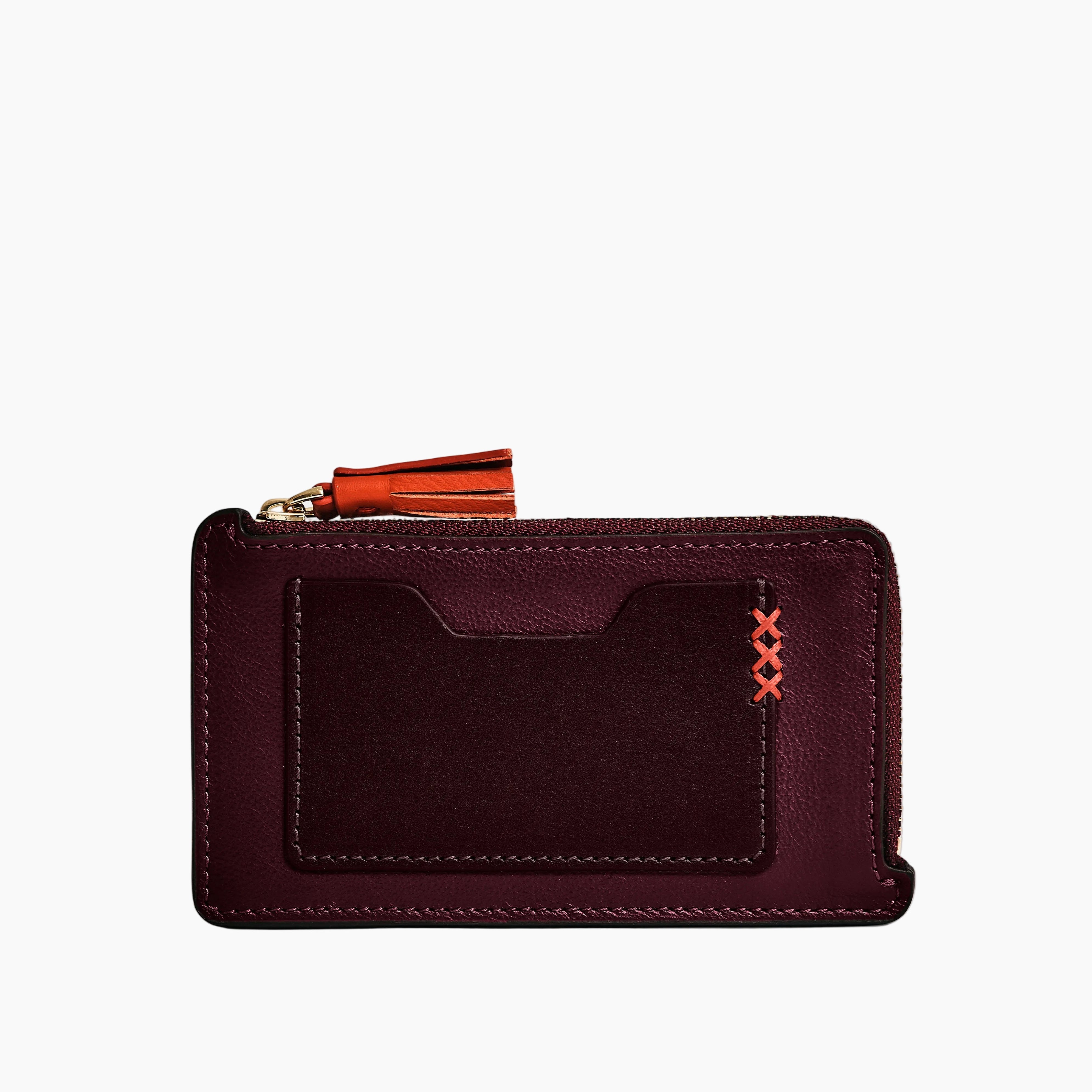 Purple wallet with orange zipper on a light gray background
