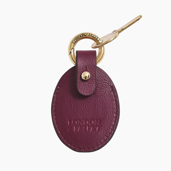 Purple leather key fob with gold ring on a white background