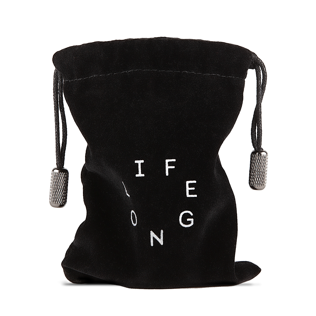 Black travel bag for refillable deodorant  from the brand Lifelongdeo. Bag is velvet with a circle white logo saying Lifelong. The straps has knurled metal details in the ends. 
