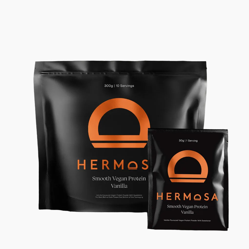 Two packages of Hermosa Smooth Vegan Protein Vanilla on a dark background