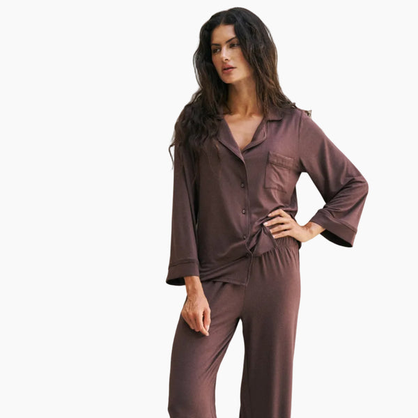 Woman wearing a brown pajama set against a white background