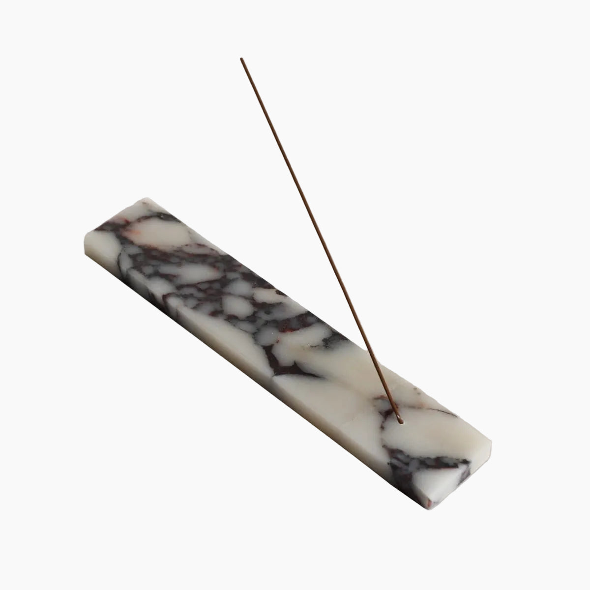 Marble-patterned incense stick holder with a single incense stick on a beige background