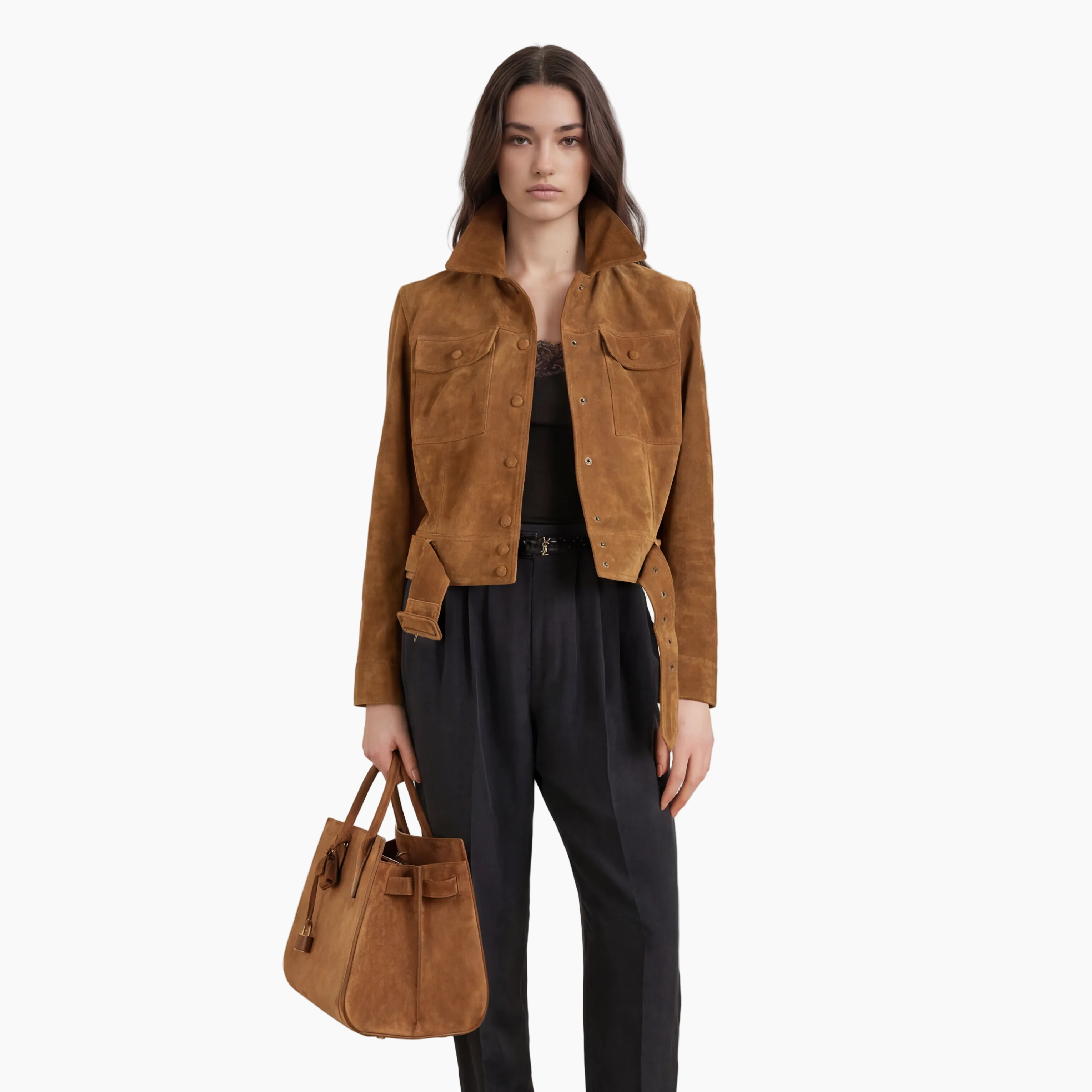 Woman wearing a brown jacket and black pants holding a brown handbag on a white background