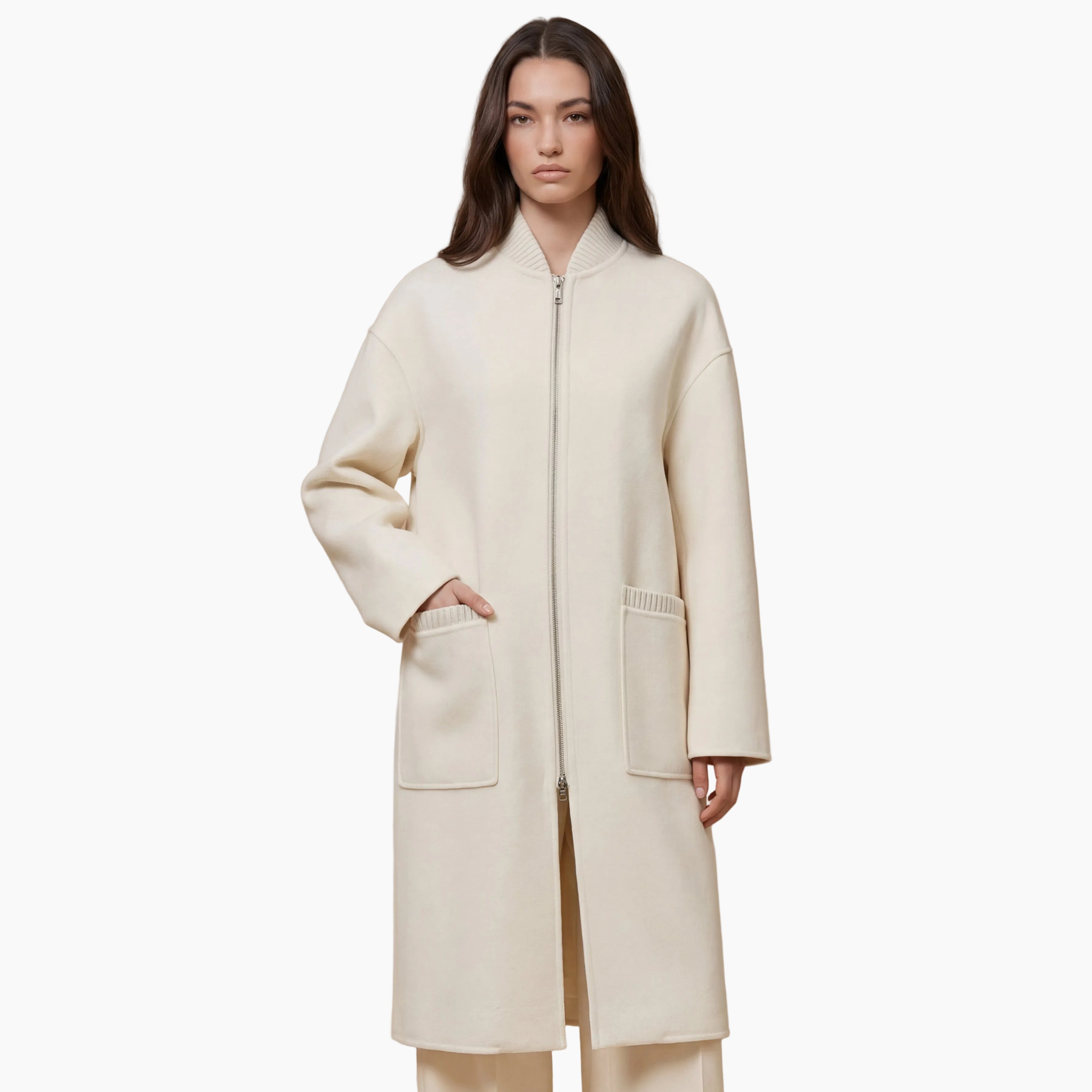 Woman wearing a long cream coat against a beige background
