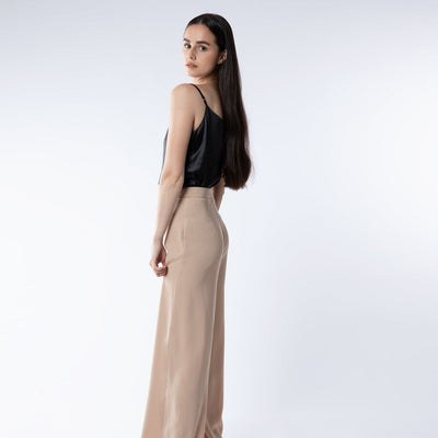 Lady wearing black silk cami top with camel trousers