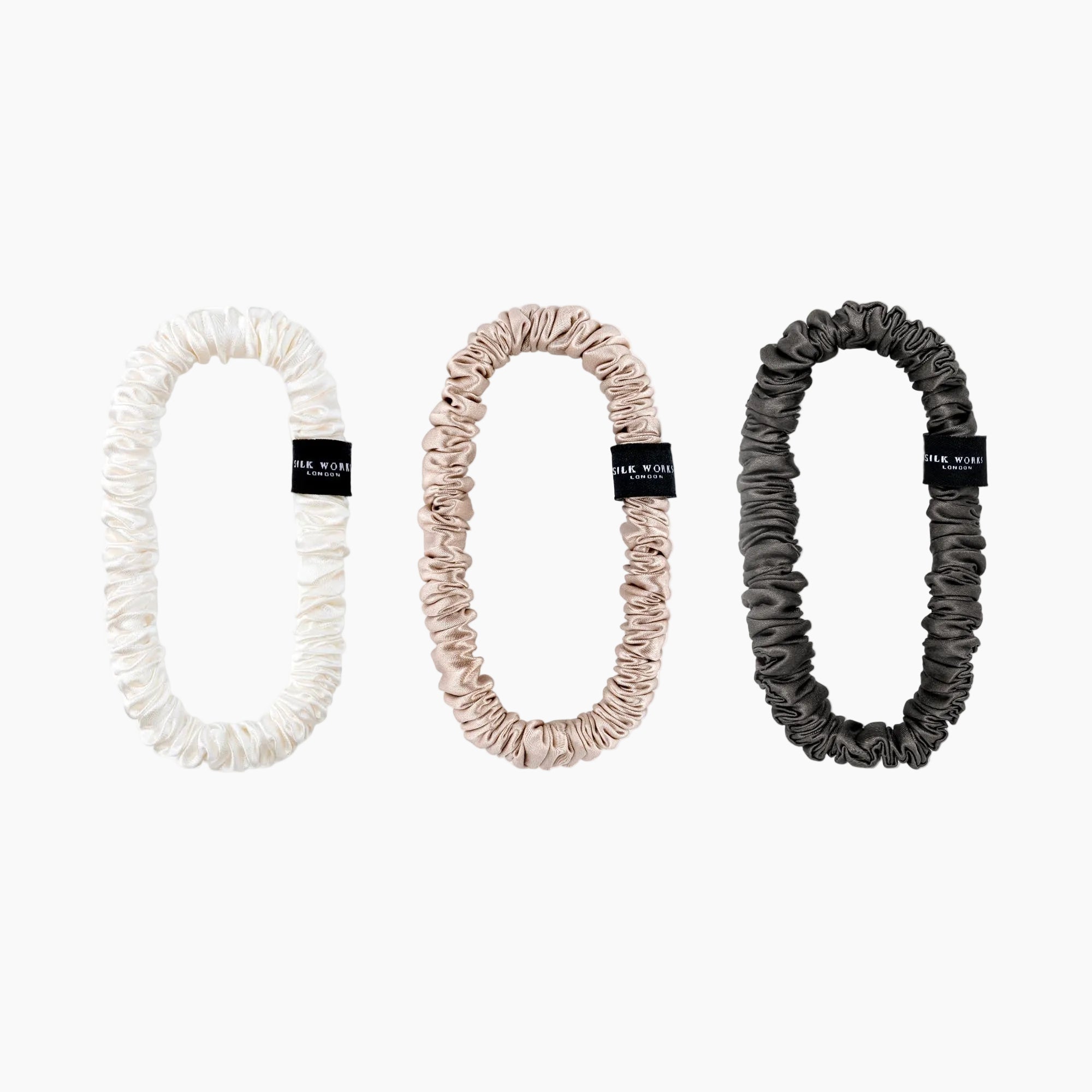 Set of three Silk Works mulberry silk scrunchies in ivory, caramel, and charcoal grey – soft, gentle, and perfect for everyday styling