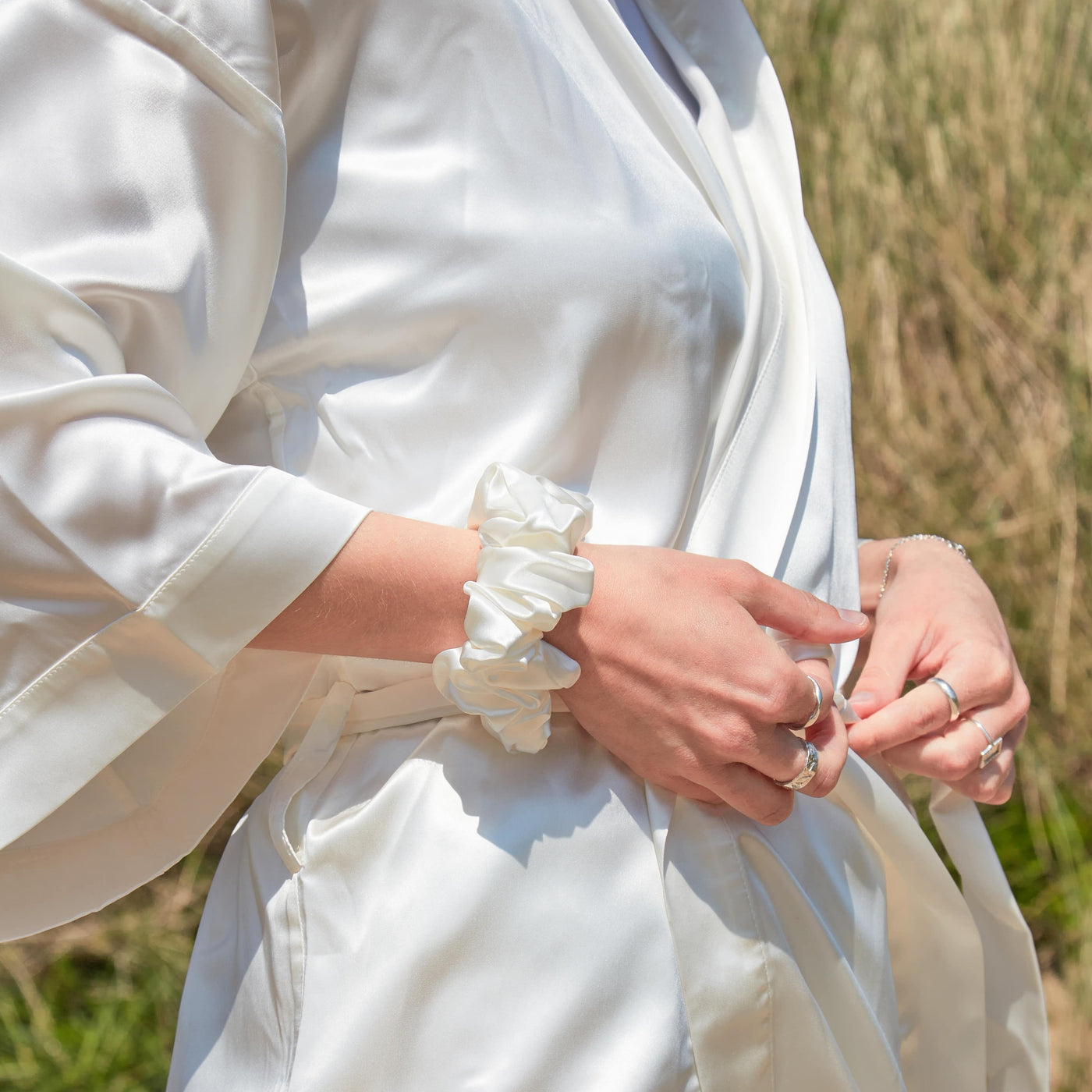 lady wear ivory silk robe with ivory silk scrunchie on wrist 