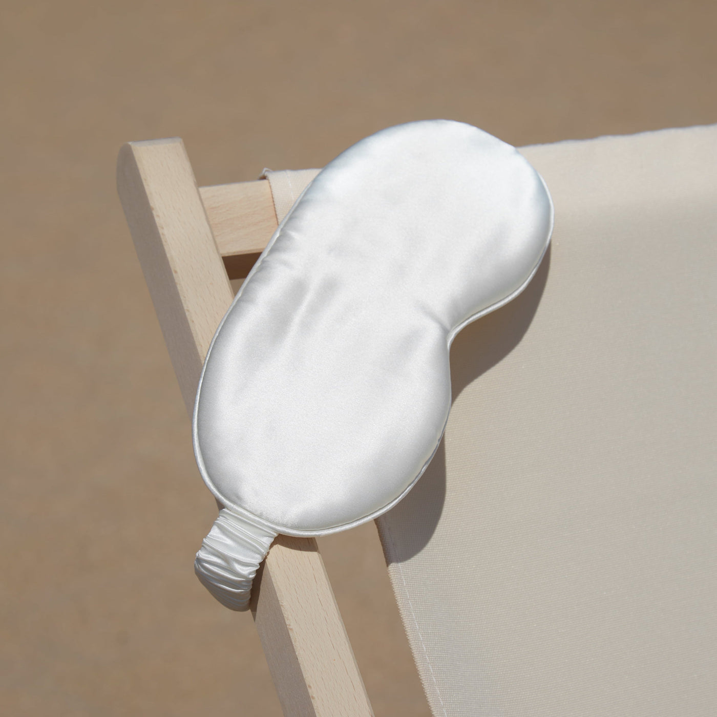 Ivory silk eye mask on deck chair