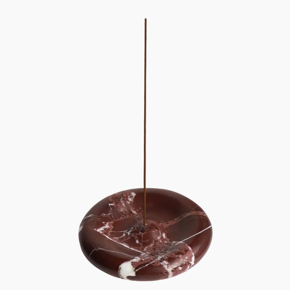Marble-patterned incense holder with a single incense stick on a beige background