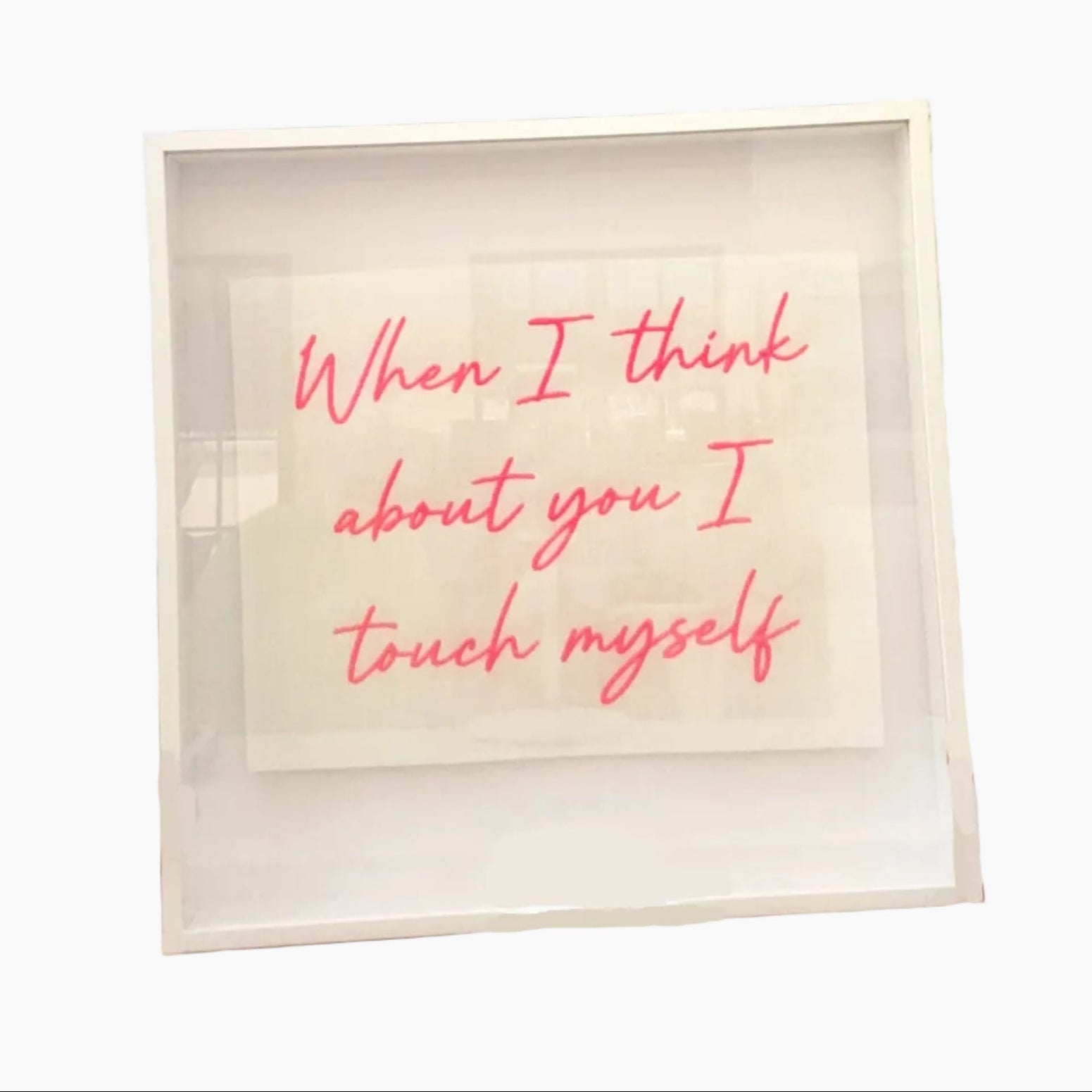 Person holding a framed quote with pink text against a neutral background