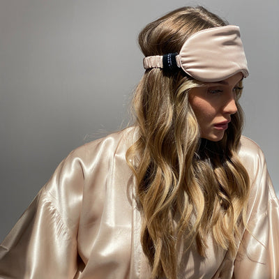 Woman wearing a neutral coloured silk eye mask