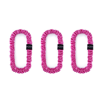 Trio of fuchsia 100% mulberry silk skinny scrunchies by Silk Works, designed to reduce breakage and frizz.