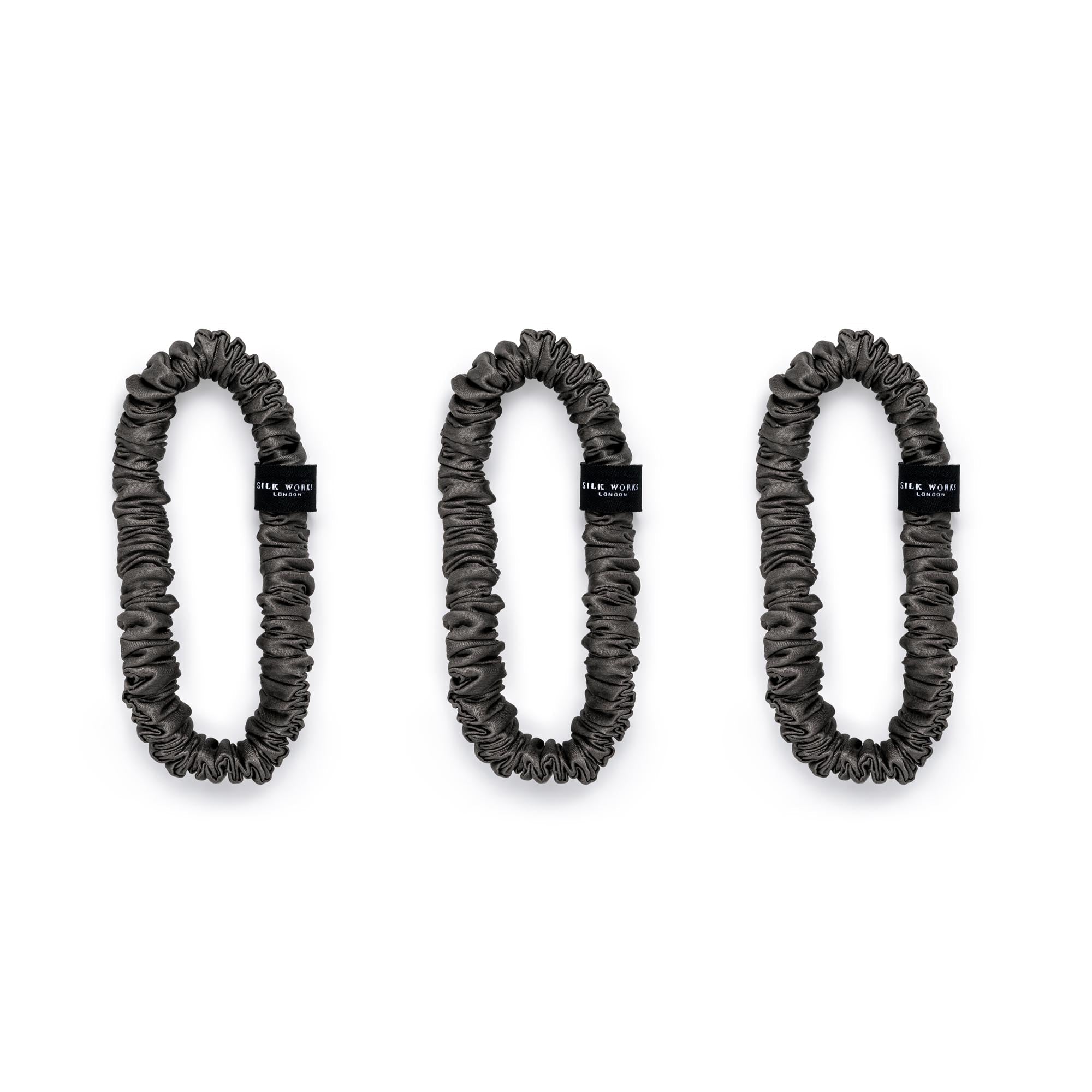 Trio of  charcoal grey 100% mulberry silk skinny scrunchies by Silk Works, designed to reduce breakage and frizz.