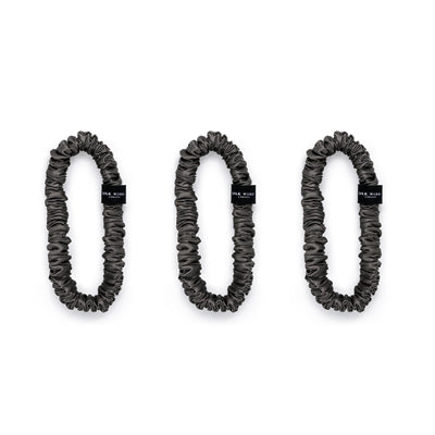 Trio of  charcoal grey 100% mulberry silk skinny scrunchies by Silk Works, designed to reduce breakage and frizz.