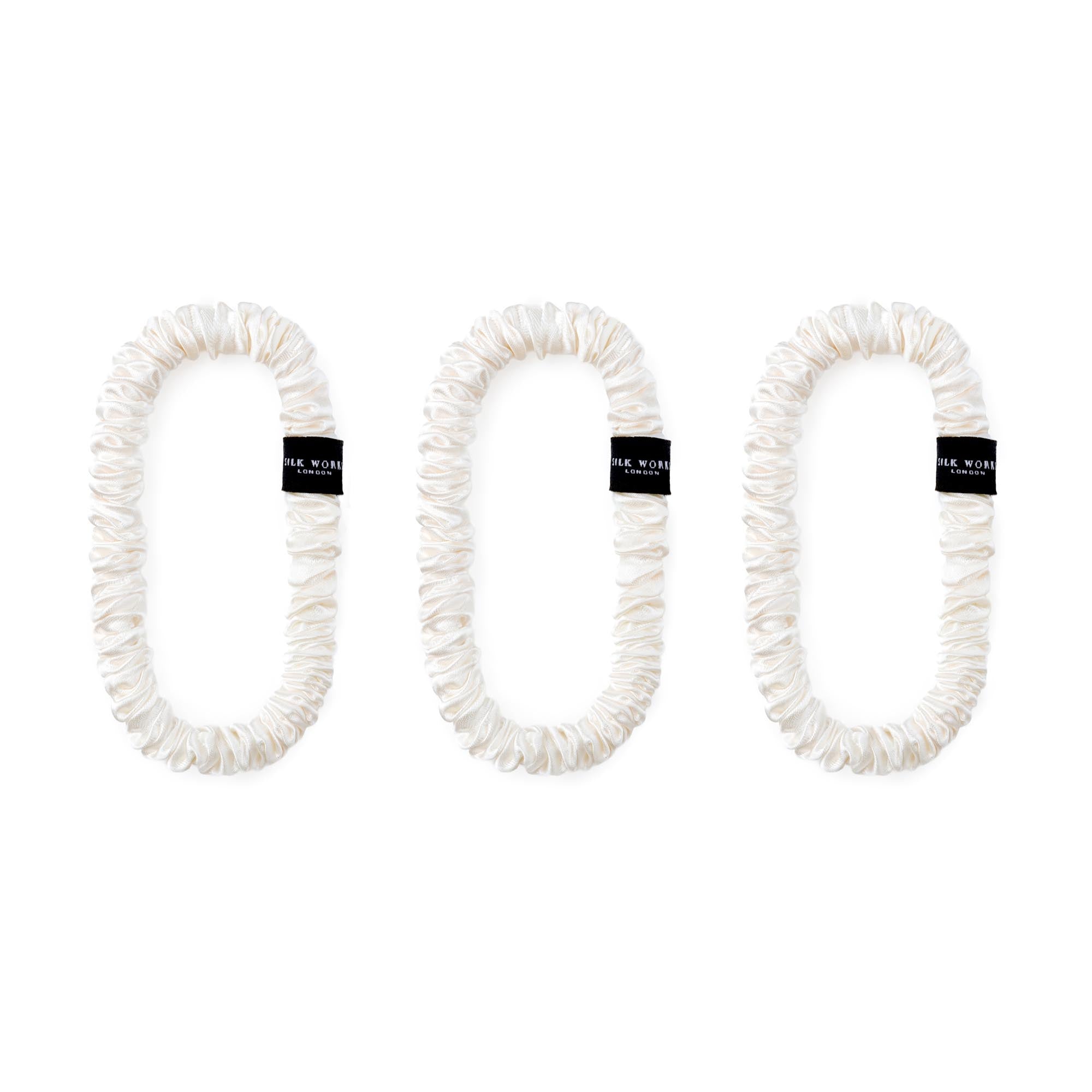 Trio of ivory 100% mulberry silk skinny scrunchies by Silk Works, designed to reduce breakage and frizz.