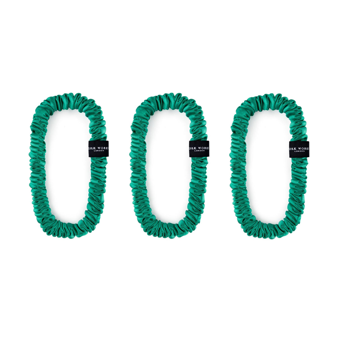 Trio of jade green 100% mulberry silk skinny scrunchies by Silk Works London, designed to reduce hair breakage and frizz.